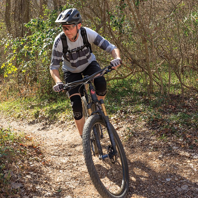 A person mountain biking down a trail