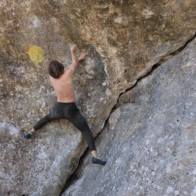A man climbing an overhanging boulder