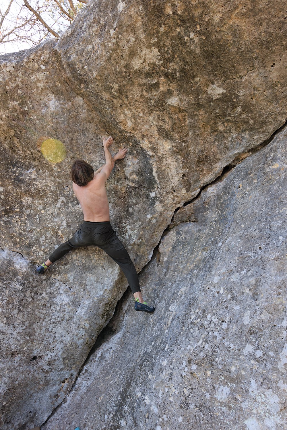 A man climbing an overhanging boulder