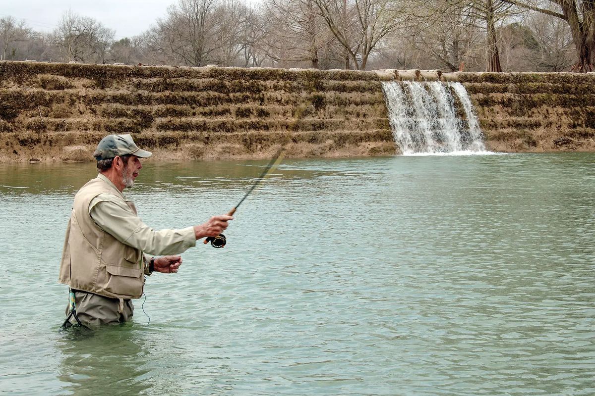 man fishing in a front of a water structure