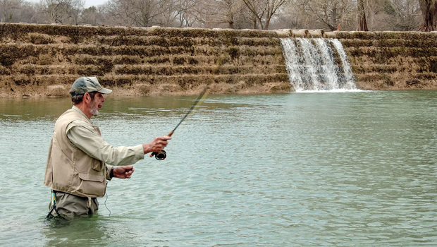 man fishing in a front of a water structure