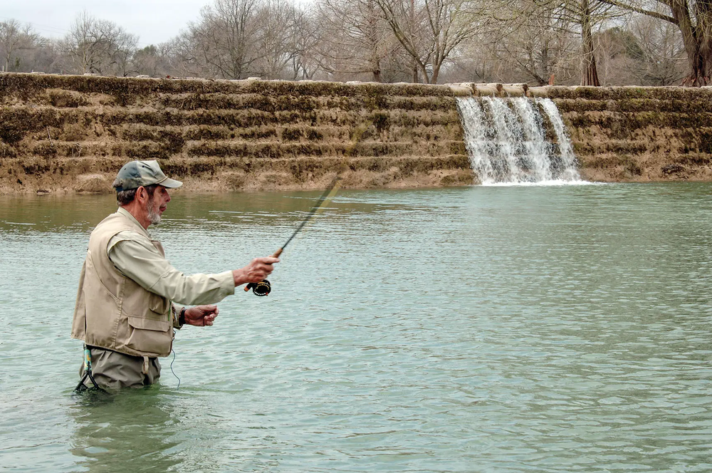 man fishing in a front of a water structure