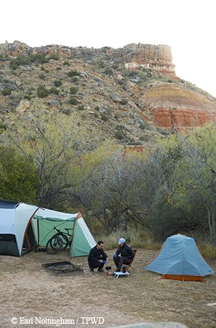two tents and people setting up camp in the paloduro canyon
