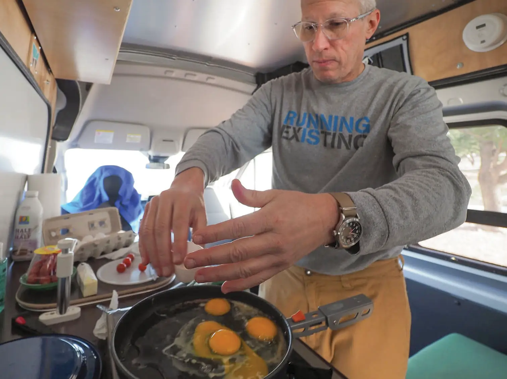 person making breakfast in a camper van