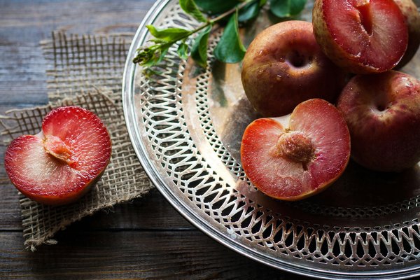 platter of plums some sliced in half