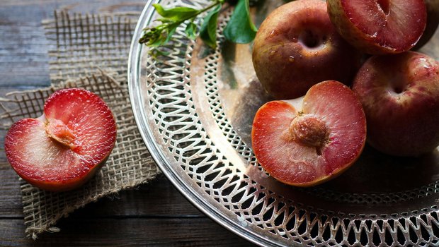 platter of plums some sliced in half