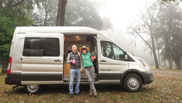 two people outside of their camper van