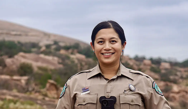 game warden Wei-Wei Lin standing at the base of a rocky hill
