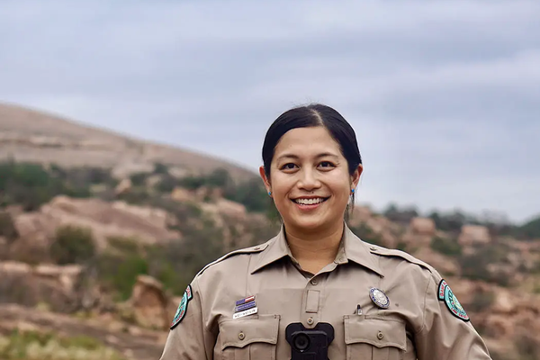 game warden Wei-Wei Lin standing at the base of a rocky hill