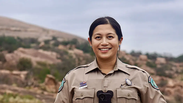 game warden Wei-Wei Lin standing at the base of a rocky hill