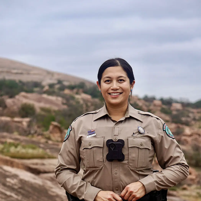 game warden Wei-Wei Lin standing at the base of a rocky hill
