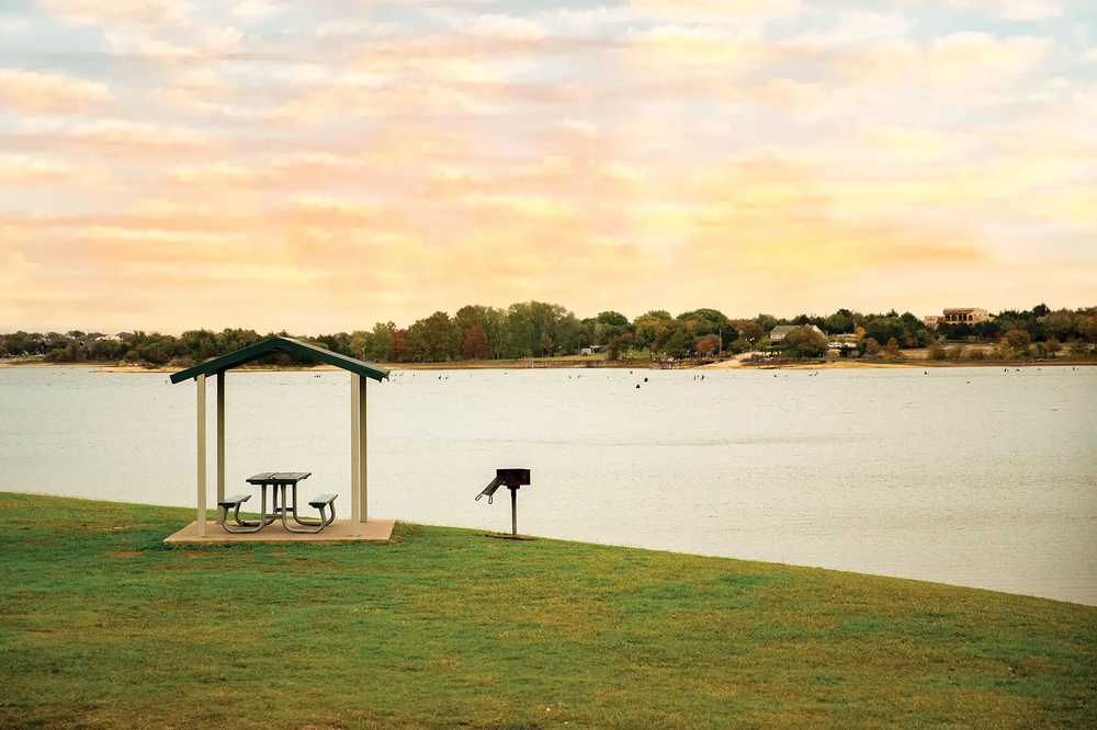 lake waxahachie at sunset with a pavilion and a grill