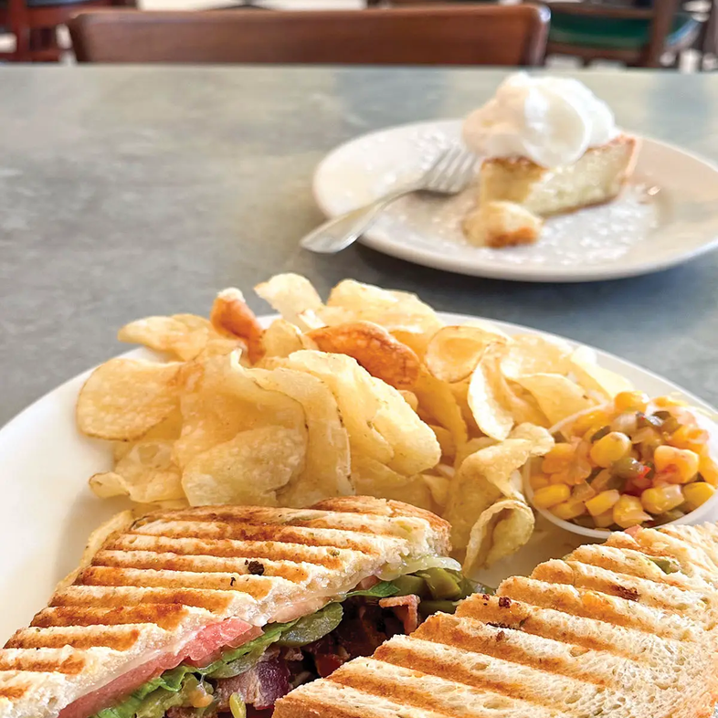 waxahachie restaraunt with a sandwich and chips on a plate and a plate with pie