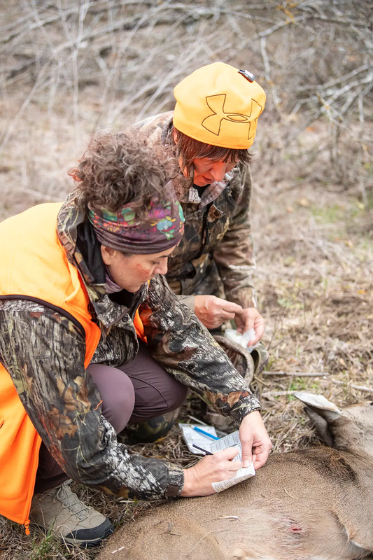 women tagging a deer